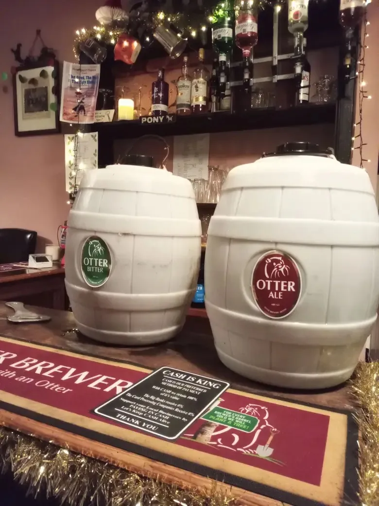 Two kegs of Otter ale placed on top of bar.